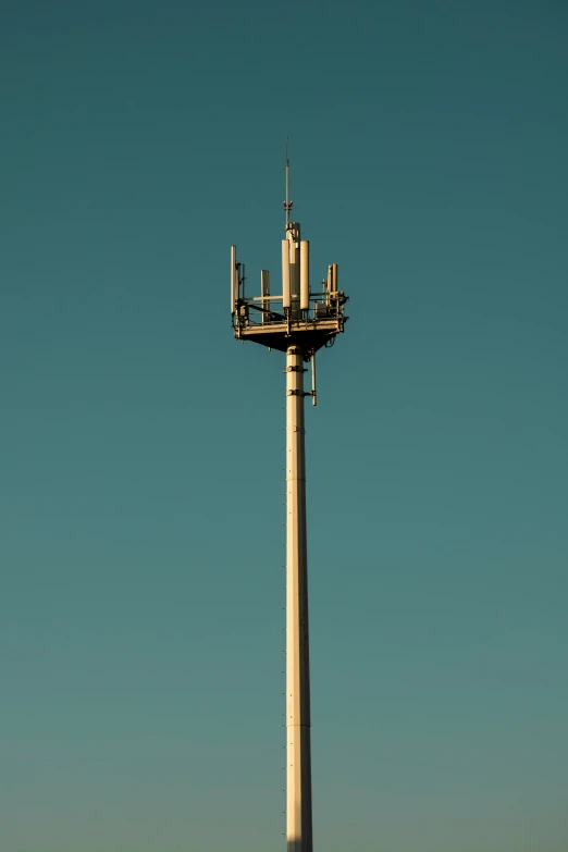 the cellphone tower is sitting at the top of a hill