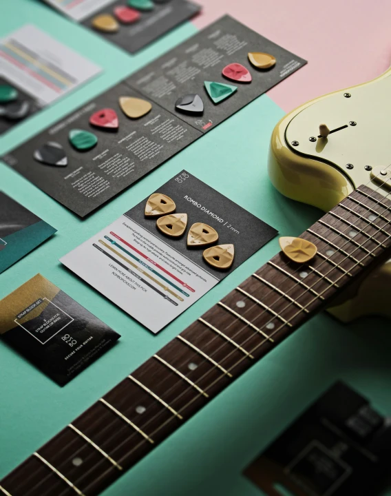 a guitar, notecards, and a clock on a green table