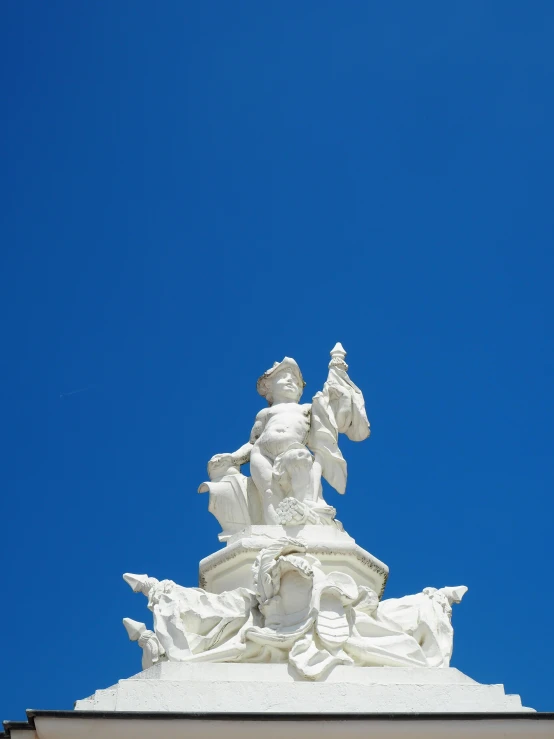 a tall white statue on top of a building