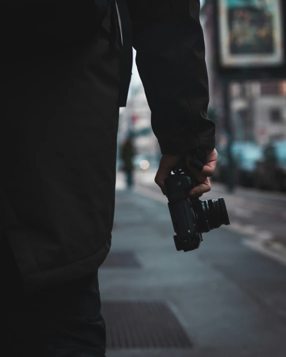 a man carrying a camera down the sidewalk