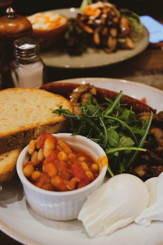 this meal features baked beans, bread, greens and tomato sauce