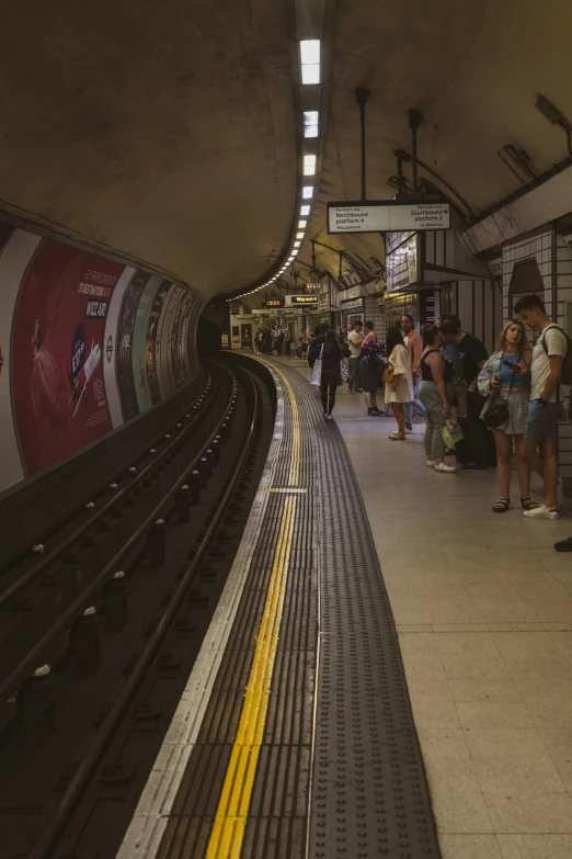 a subway station with many people waiting for the trains