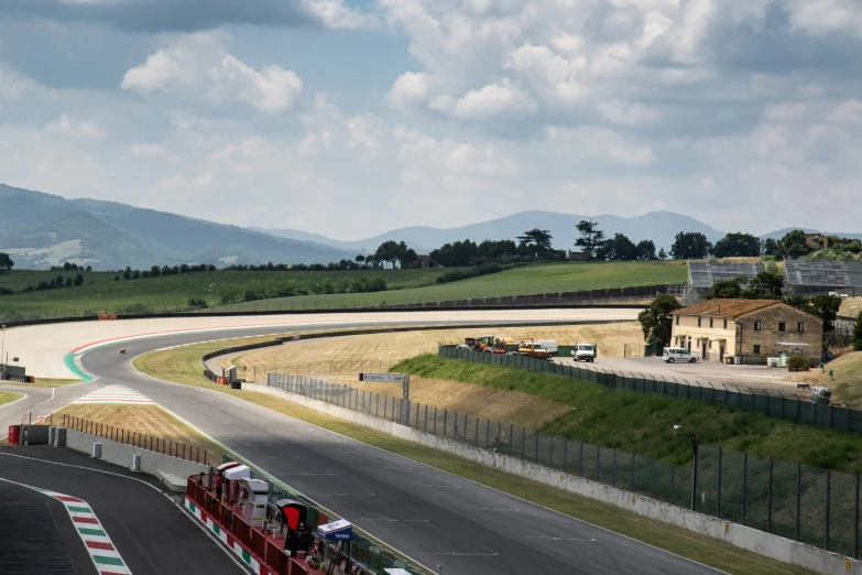 race cars driving around the track in the day