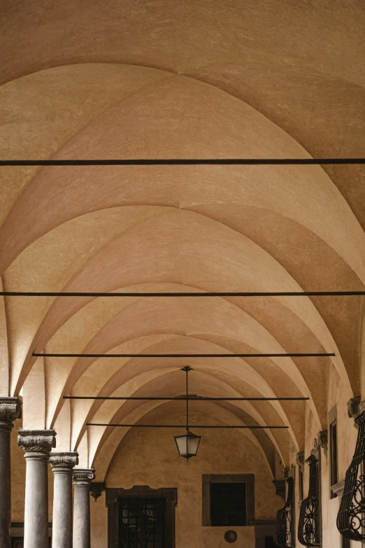 rows of pillars line the corridor leading into a building