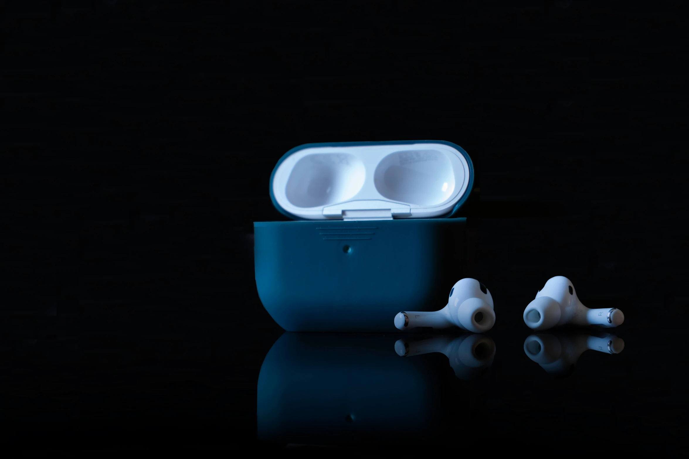 two ear buds sit in a plastic container