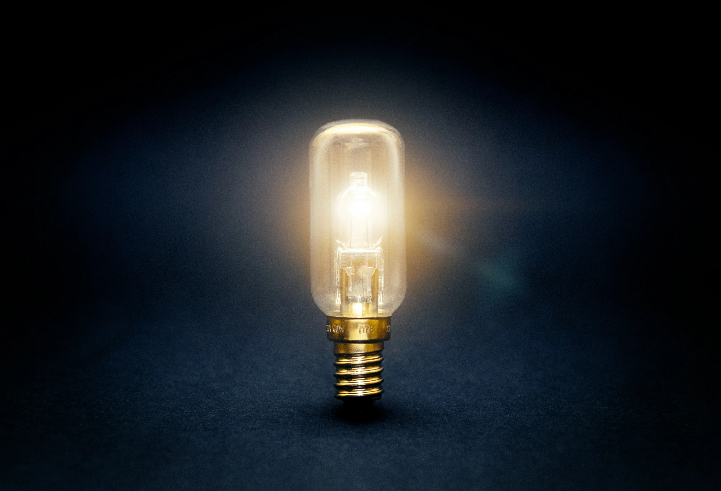 a lit up light bulb on the dark surface