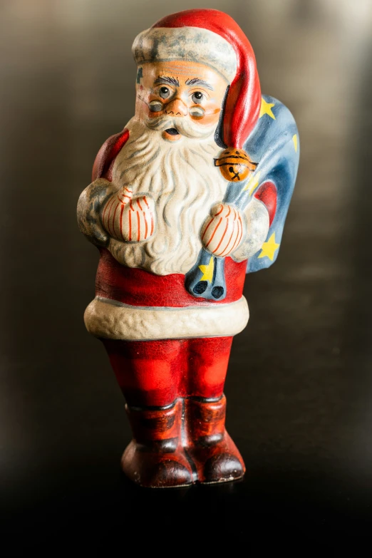 a santa claus doll figurine has his arm outstretched