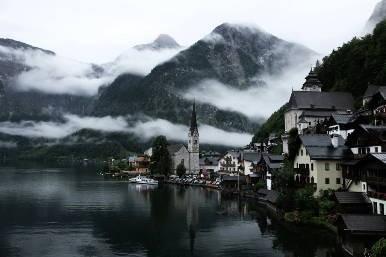 a town and its surrounding mountains sitting on the side of a lake