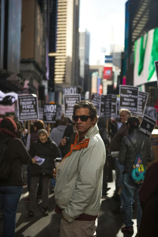 a man holding up signs with some other people in the background