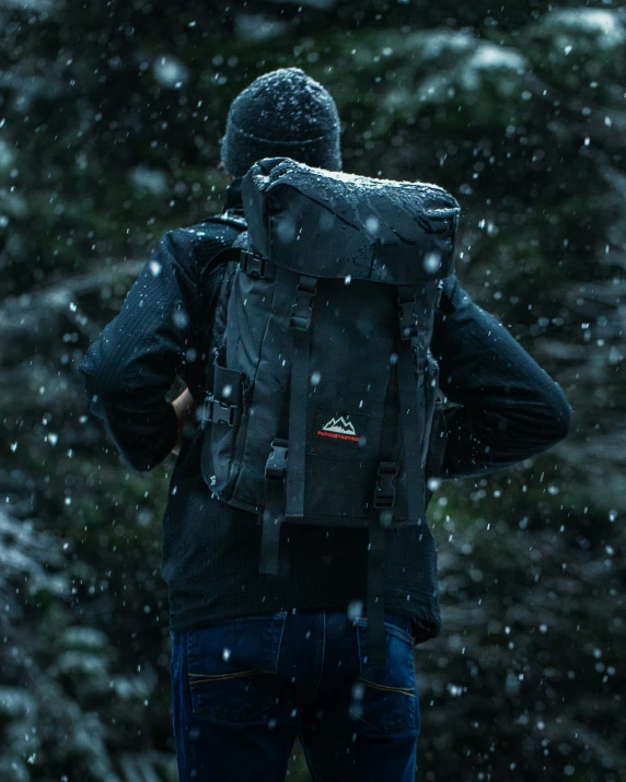 a man in a backpack walking through the snow