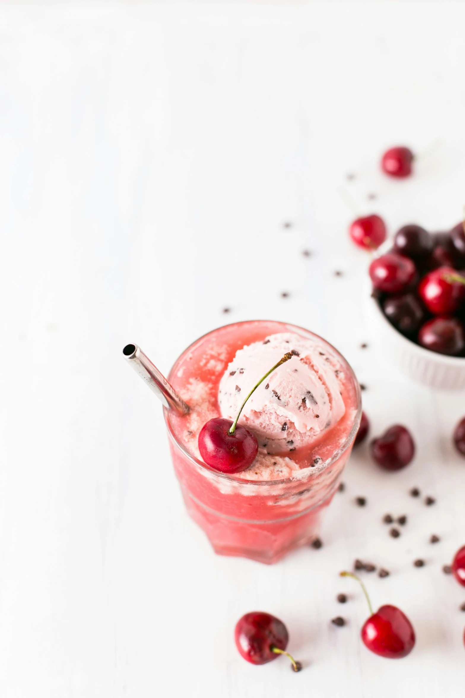 a bowl with a scoop of ice cream and some cherries