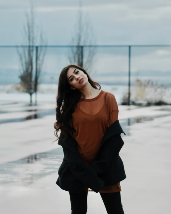 a girl in an orange top standing outside