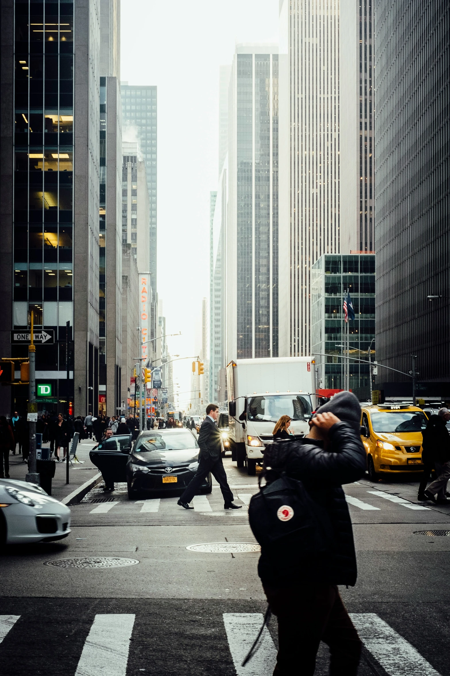 several people crossing the street in front of buildings