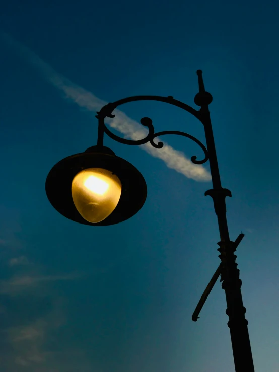 a street light with smoke in the sky