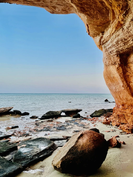 a rock formation sitting on top of a beach