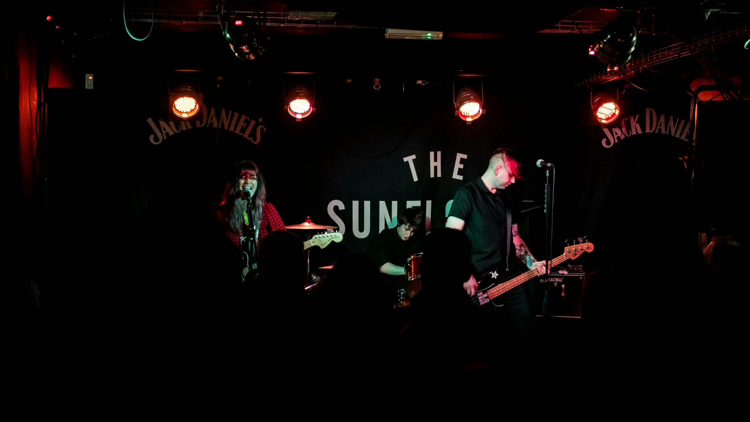 three people standing in front of microphones on stage