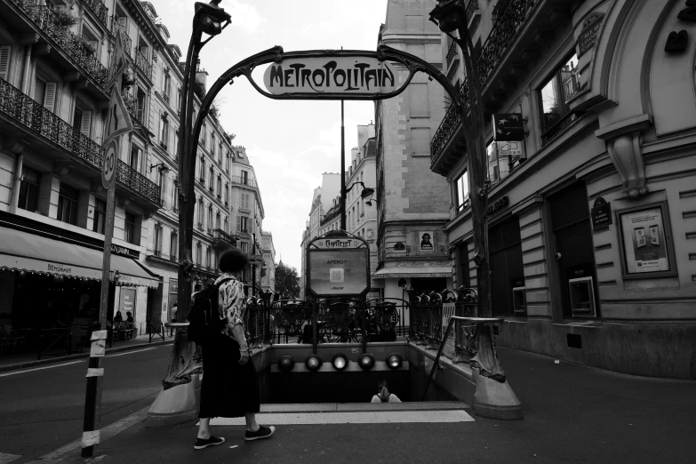 a person that is walking under a street sign