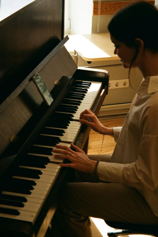 a person that is sitting near a piano