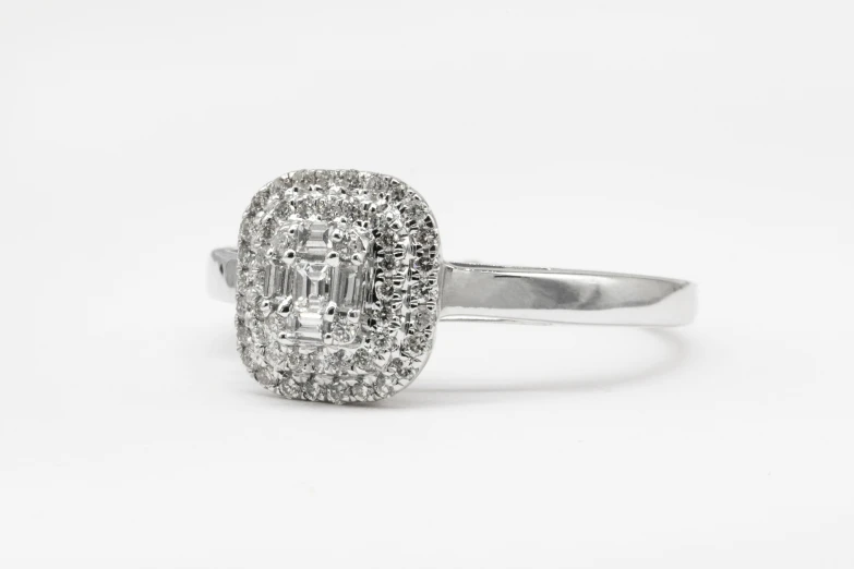 the engagement ring has a square - cut center stone with a clustered pave set diamond center stone set in the middle