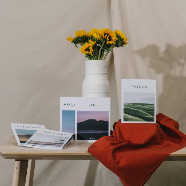 sunflowers are in a white vase next to a display on a table