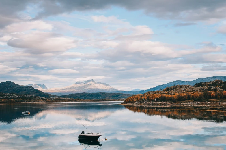 an empty boat in a lake in the mountains