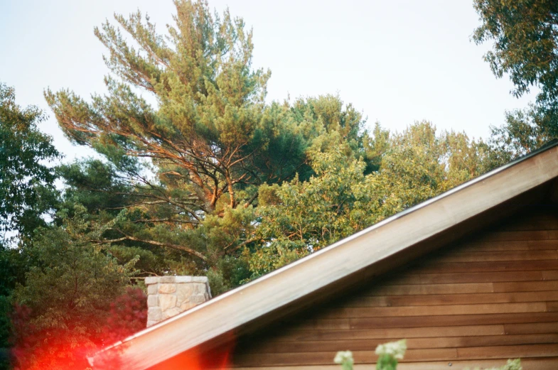 the roof of the house is brown and there are green trees in the background