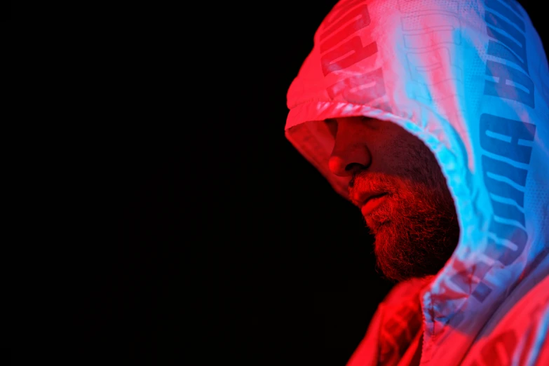 a bearded man wearing a red, white and blue hoodie