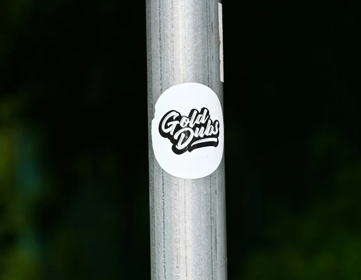 a sticker is seen on the pole of a street post