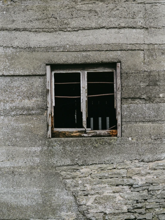 an old building with a wooden window and wires hanging from it