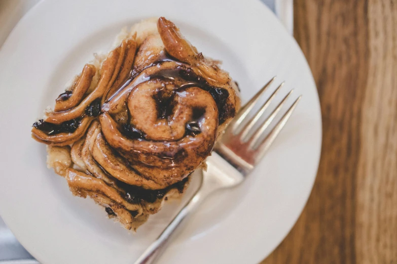 a plate of food containing a pastry, and some syrup