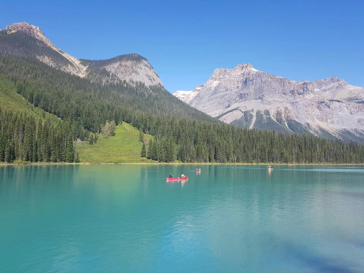 some people on canoes in a still lake