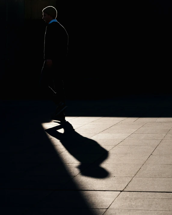 a skateboarder skates down a sidewalk at night