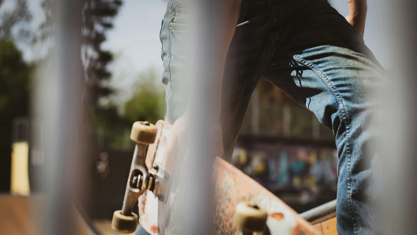 a person is standing on a skateboard and holding it in one hand