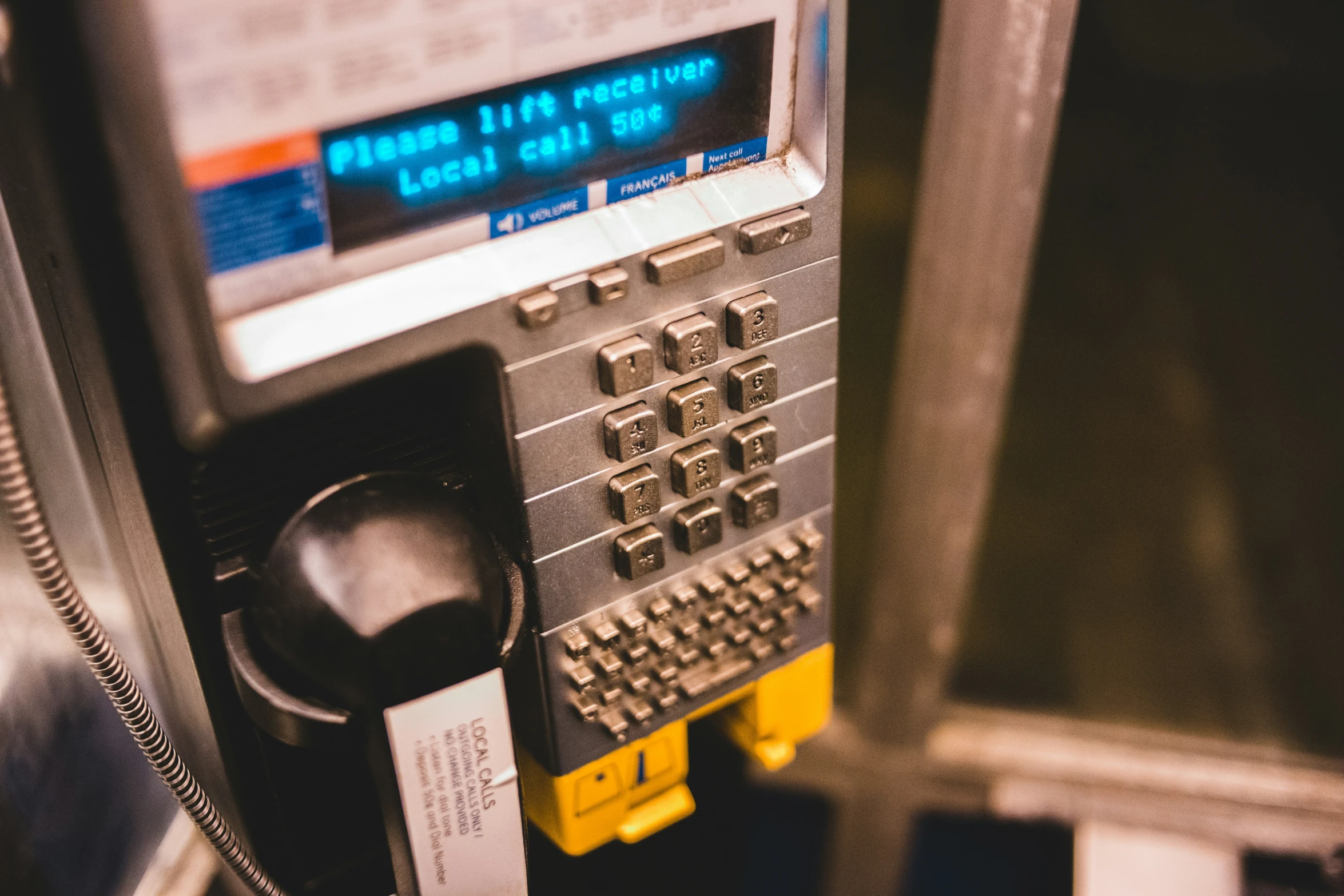 an older style pay phone near other items