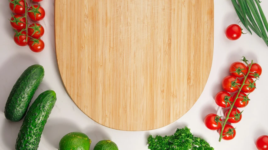 a  board surrounded by vegetables, tomatoes and cucumbers