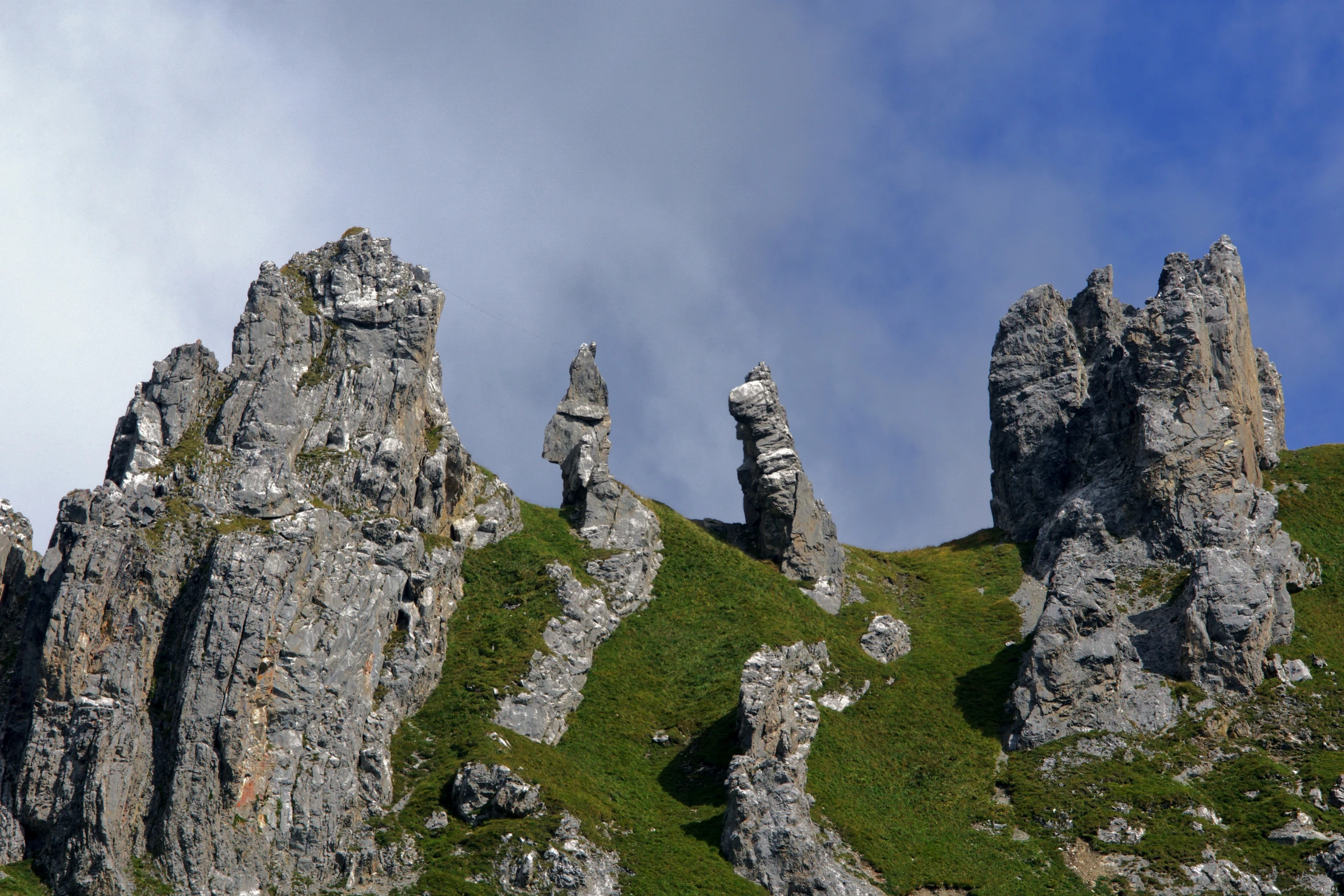 a very tall rock formation with a blue sky background