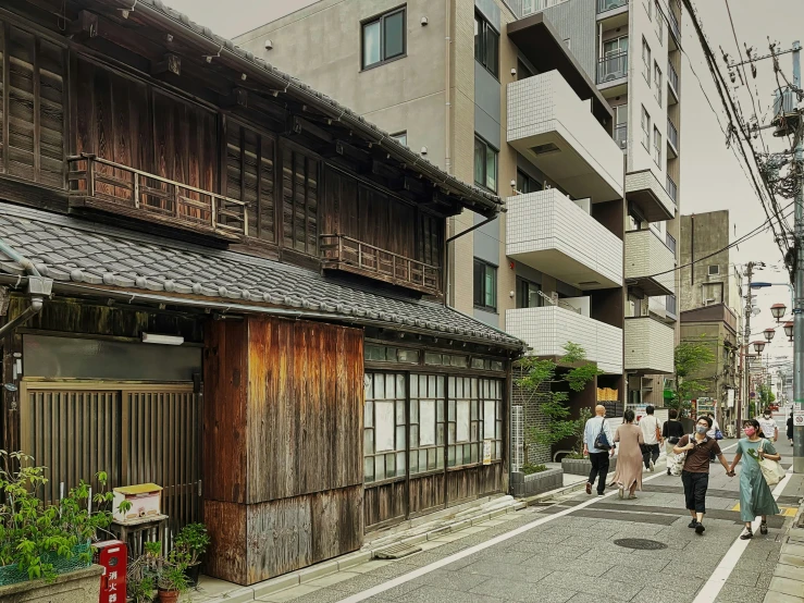 people walking down an old city street in japan