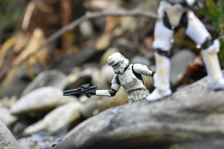 two toy action figures on a rocky area