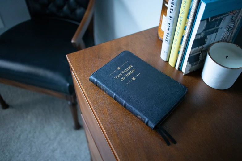 a leather case with a coffee mug next to a book