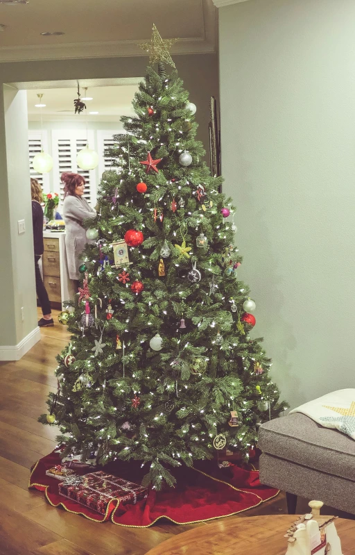 a small christmas tree with ornaments on the floor in a room