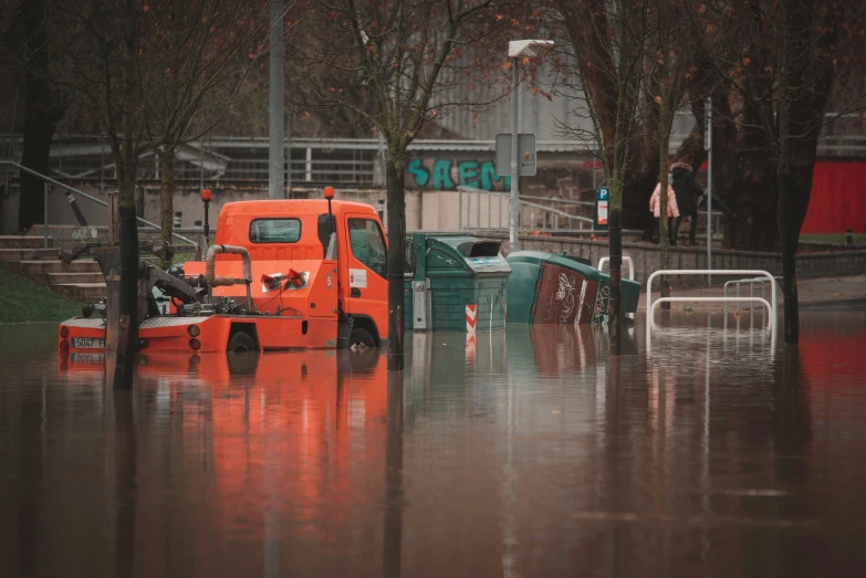 an orange truck is sitting in flood water