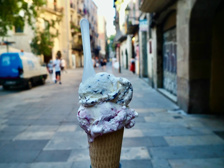 a gelato on a fork with the image taken from the sidewalk