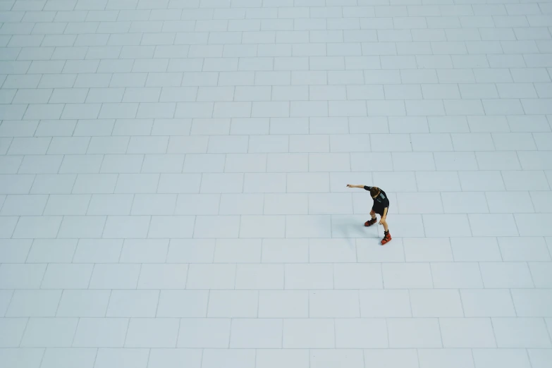 a lone person standing in the middle of a white tile floor