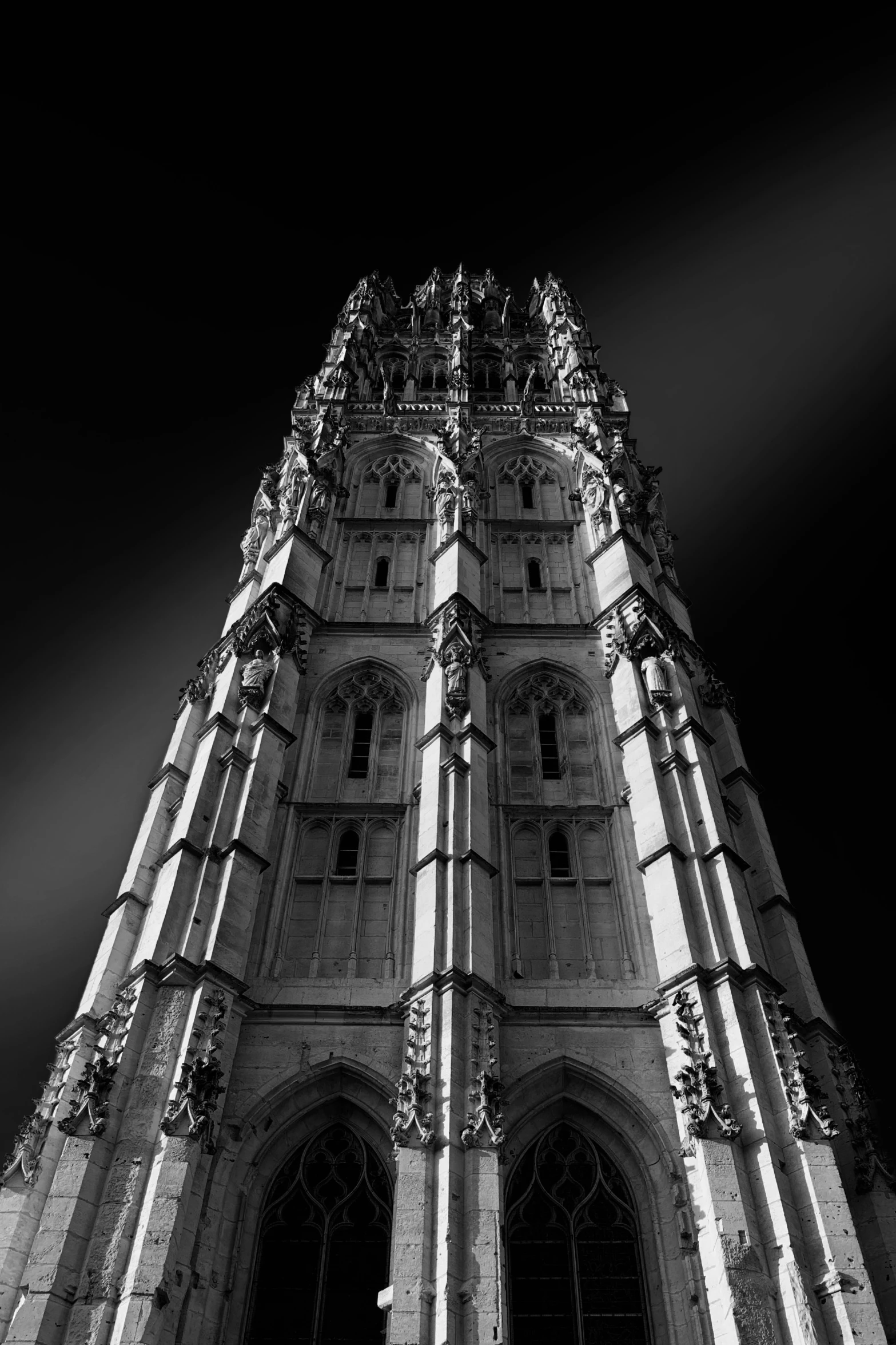 a black and white picture of a tall building with a clock