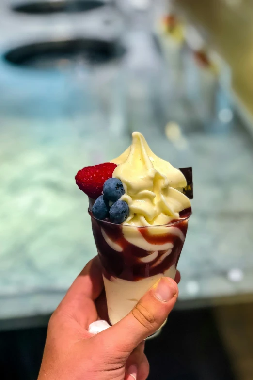 someone holding up a dessert with cream and strawberries