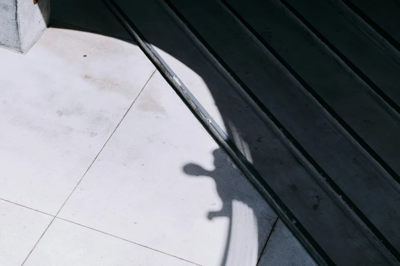 a skate board is casting a shadow on the concrete