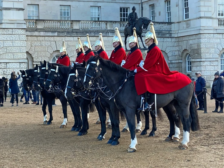 people in red coats on horses at a event