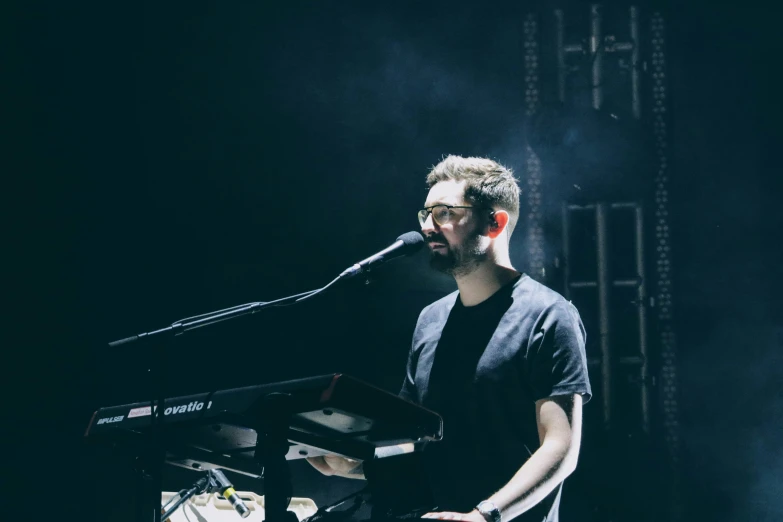 the man is playing the piano on stage