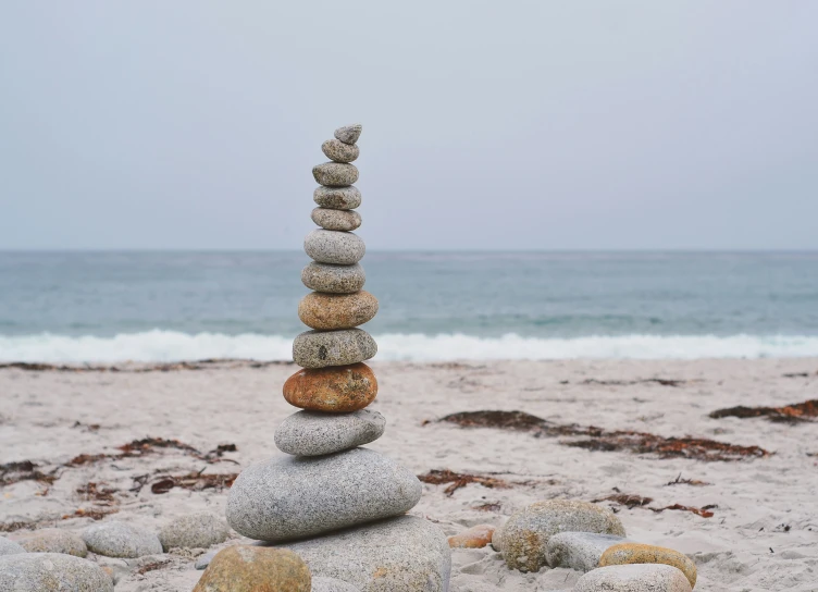stacked pebbles on the beach near an ocean