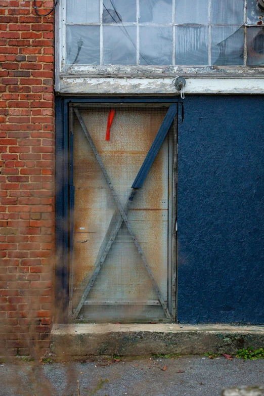 an abandoned brick building that has a garage door with a fire hydrant in the foreground